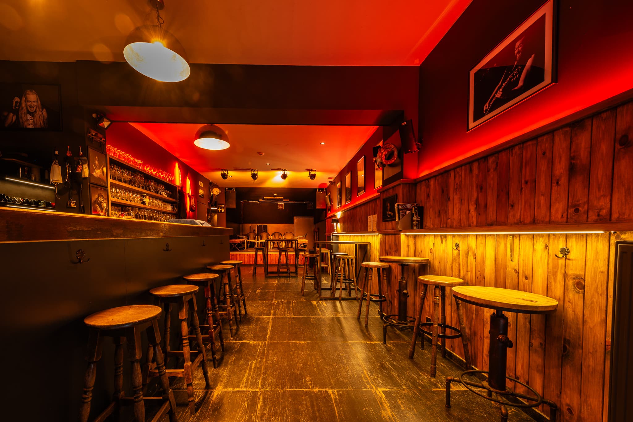 The bar and the stage at Elpee, lit in warm red and amber